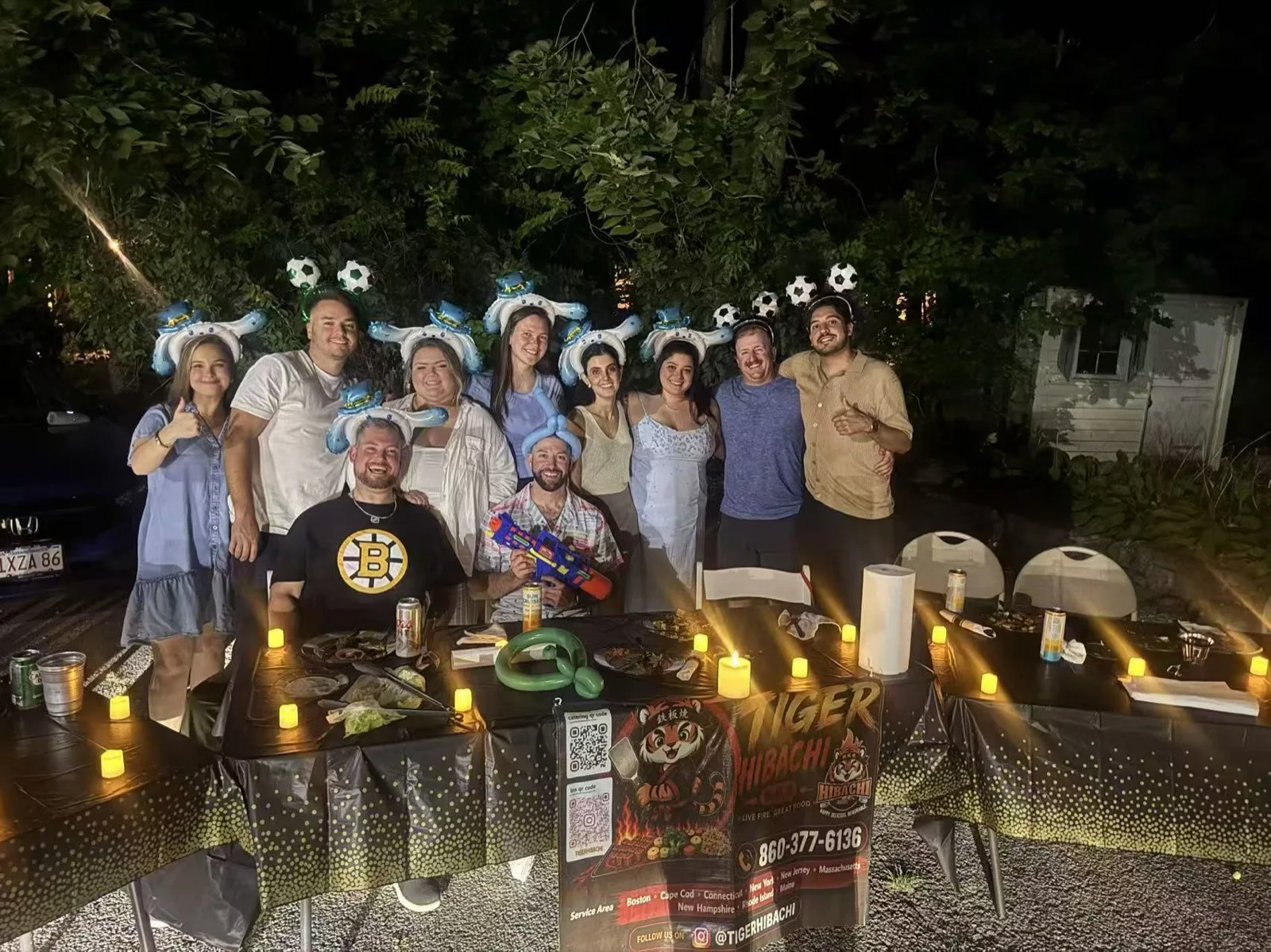 Guests gathered around a candlelit table at a nighttime Tiger Hibachi dinner party in Rhode Island