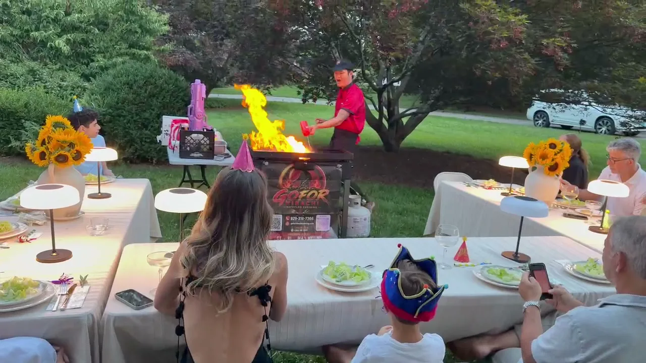 Flames rising from the teppanyaki griddle during a Rhode Island backyard hibachi fire show