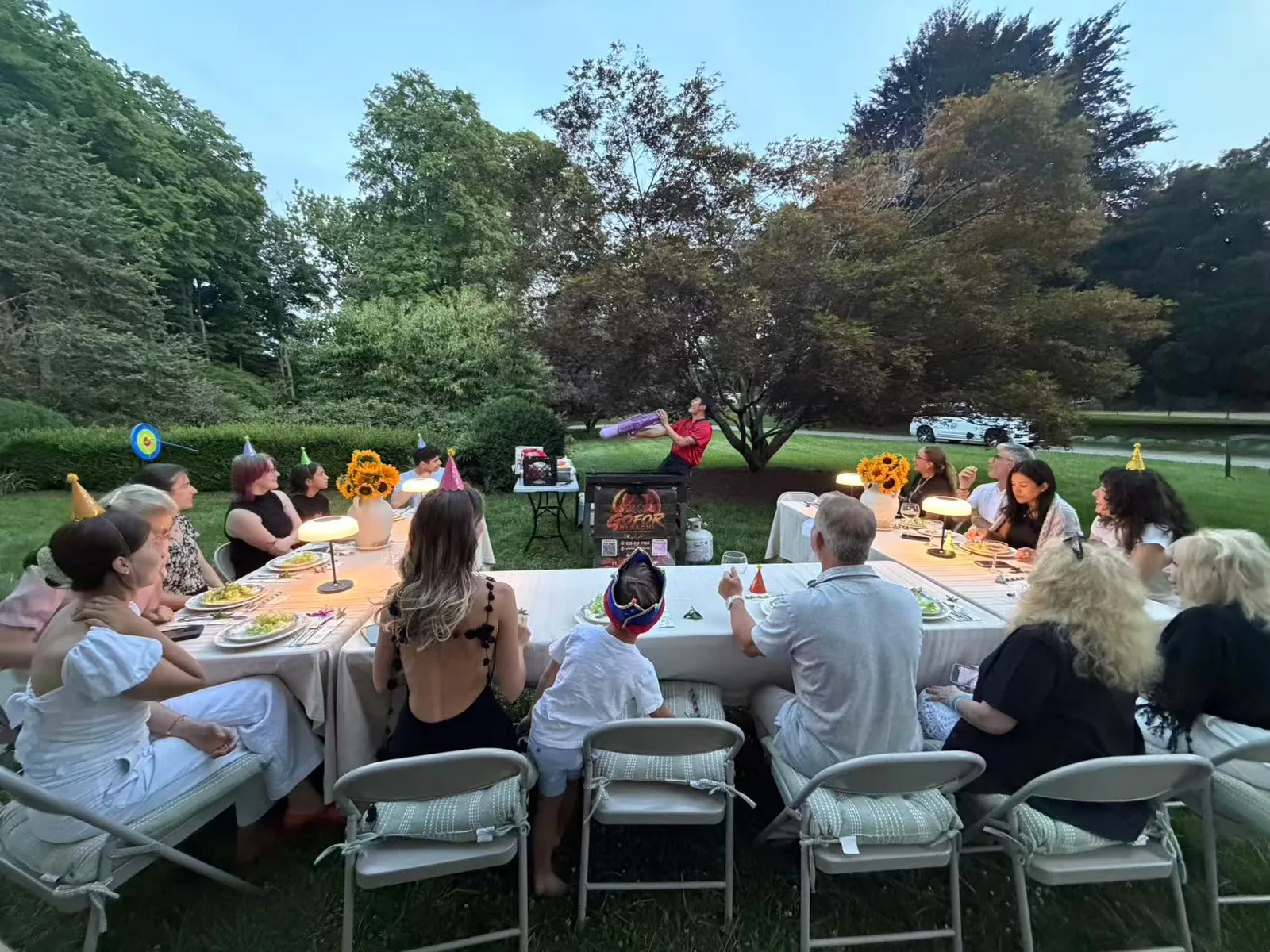 Guests seated around a long table at a sunset hibachi garden party in Rhode Island