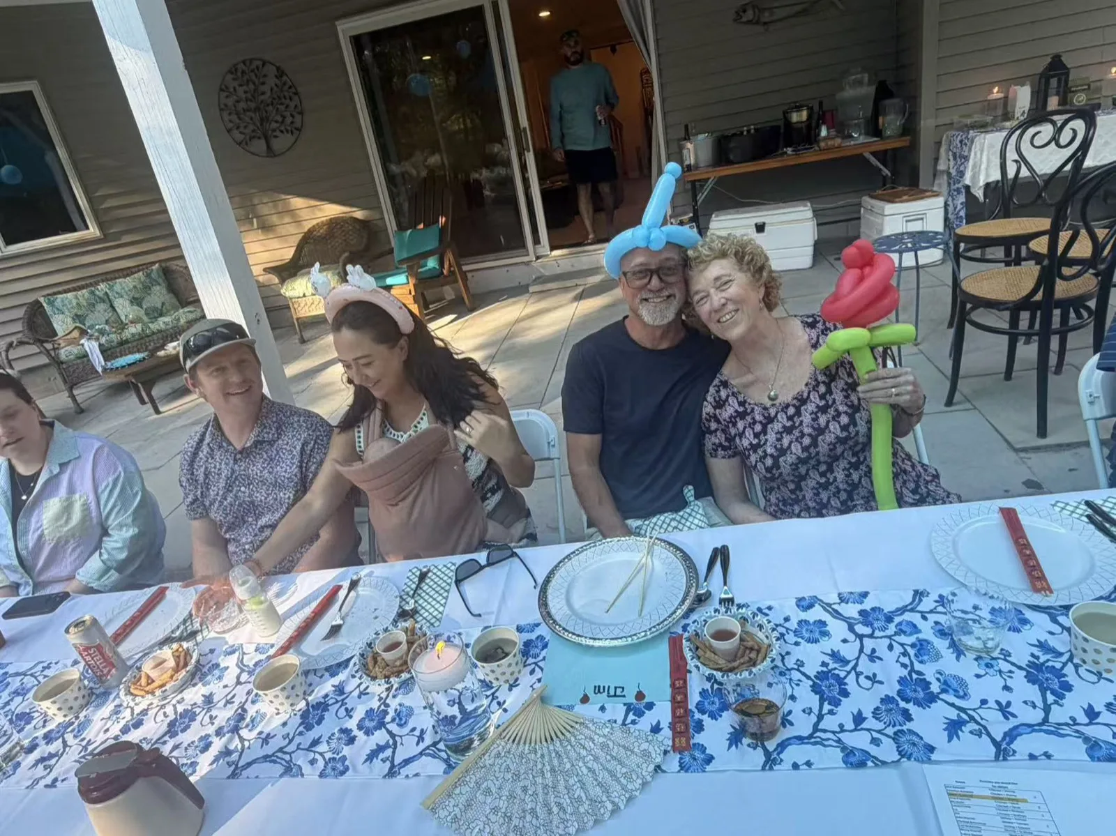 Four guests laughing together at a Tiger Hibachi party table wearing festive party hats in Rhode Island