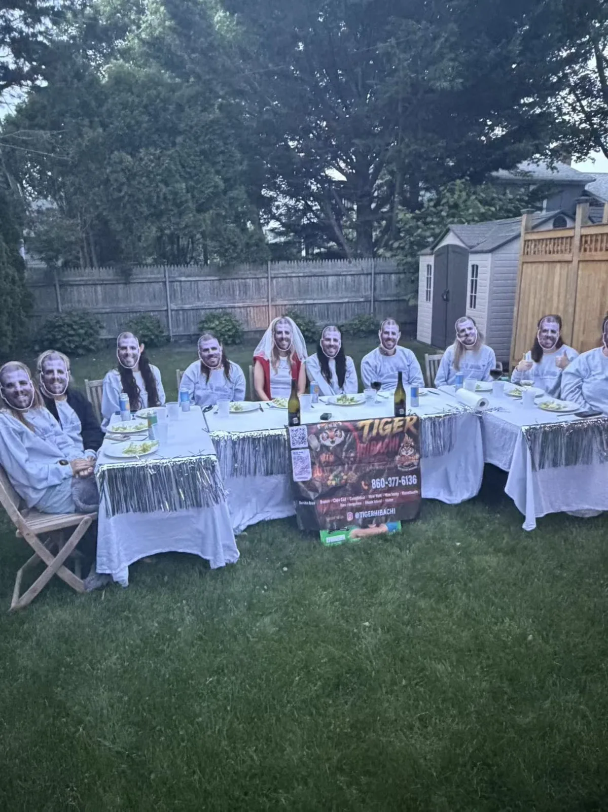 Group of guests in matching white robes seated at a long table for a hibachi party in Rhode Island