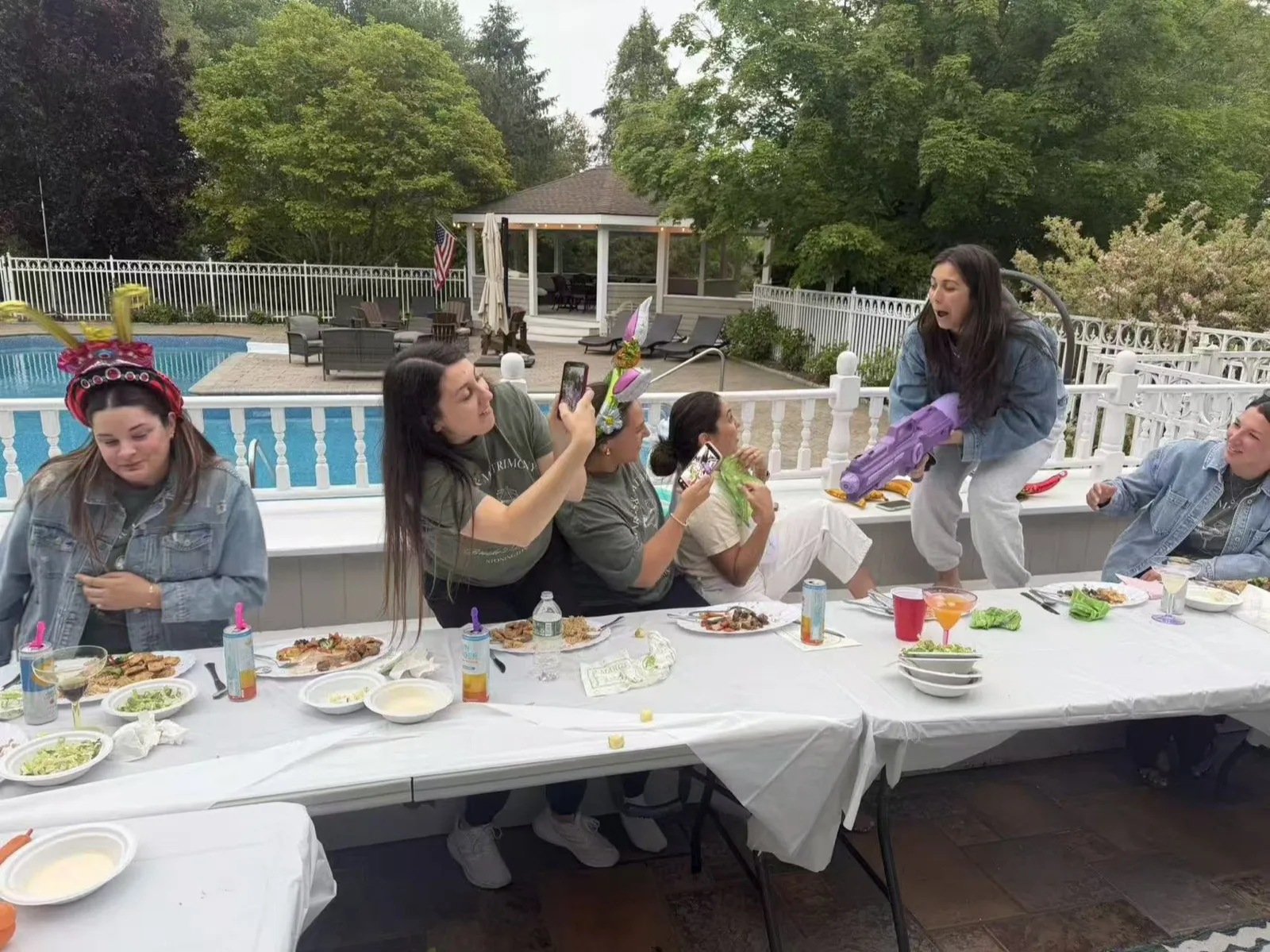 Group of friends taking a selfie with their plates at a poolside hibachi party in Rhode Island
