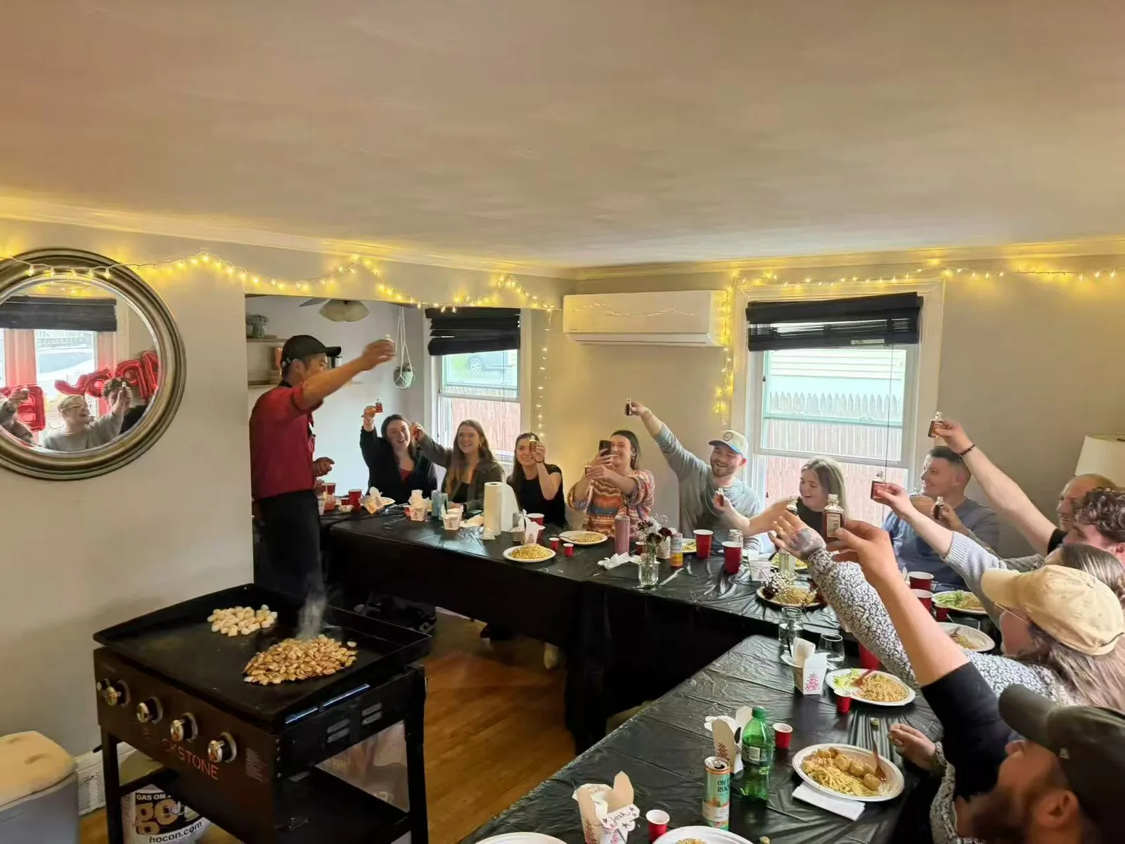 Guests raising a toast at an indoor hibachi dinner party in Rhode Island