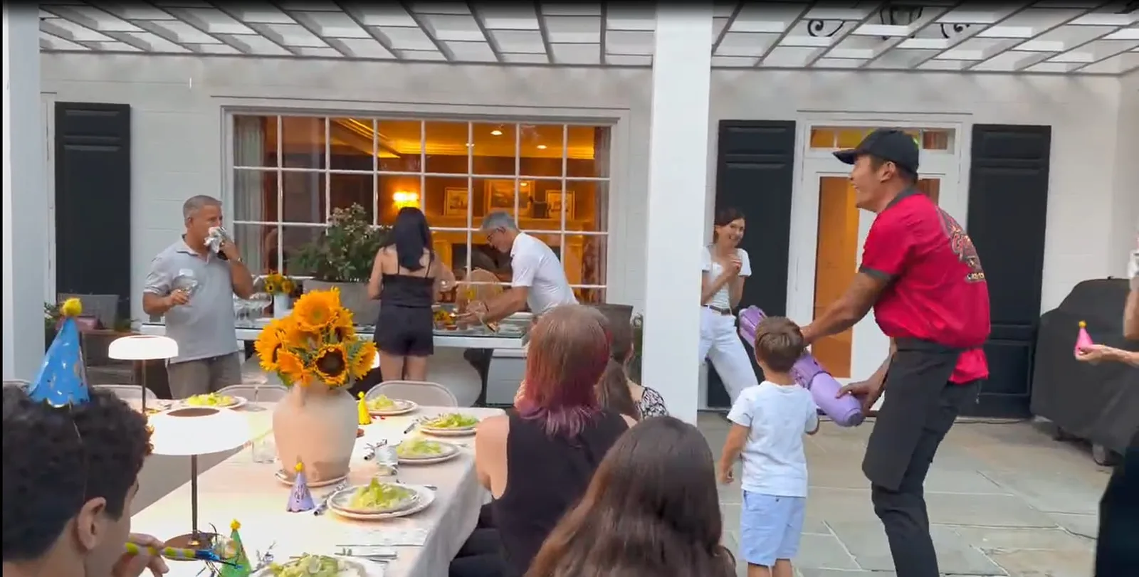 Chef handing a party prop to a child at a family hibachi party in Rhode Island
