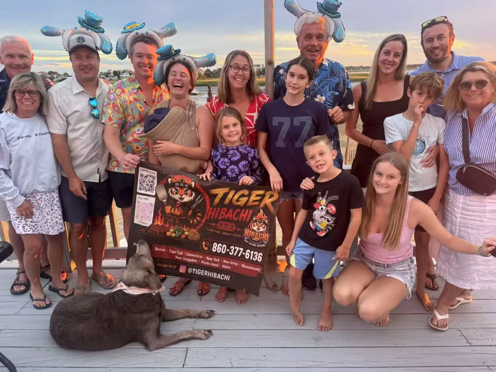 Multi-generation family posing together with their dog at a Tiger Hibachi party by the water in Rhode Island